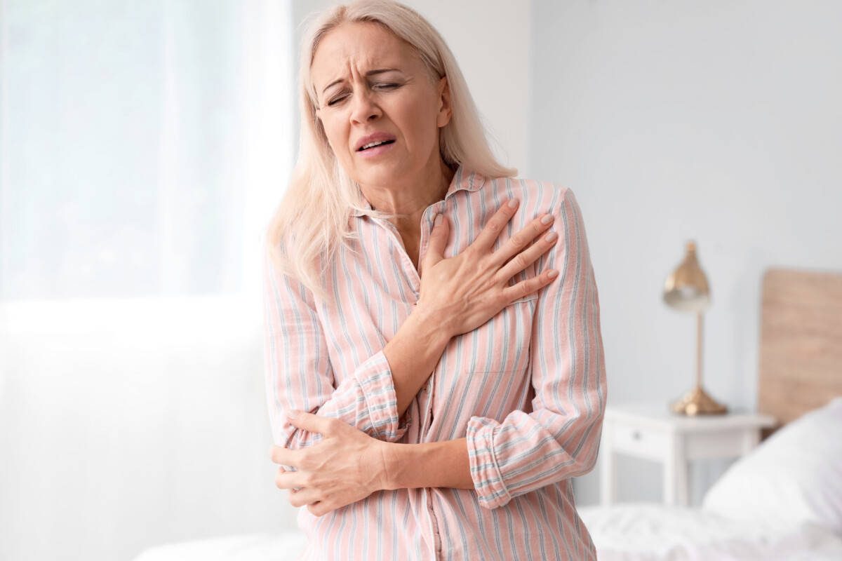 Mature woman having heart attack in bedroom