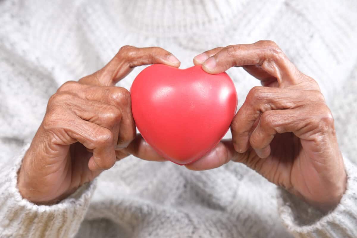 senior women holding red heart close up .