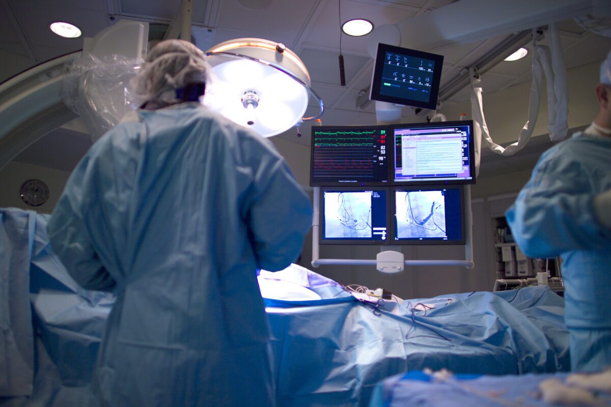 A cardiologist implants a heart defibrillator in a patient. Focus is on the fluoroscopy monitors. (14MP camera, real operation).