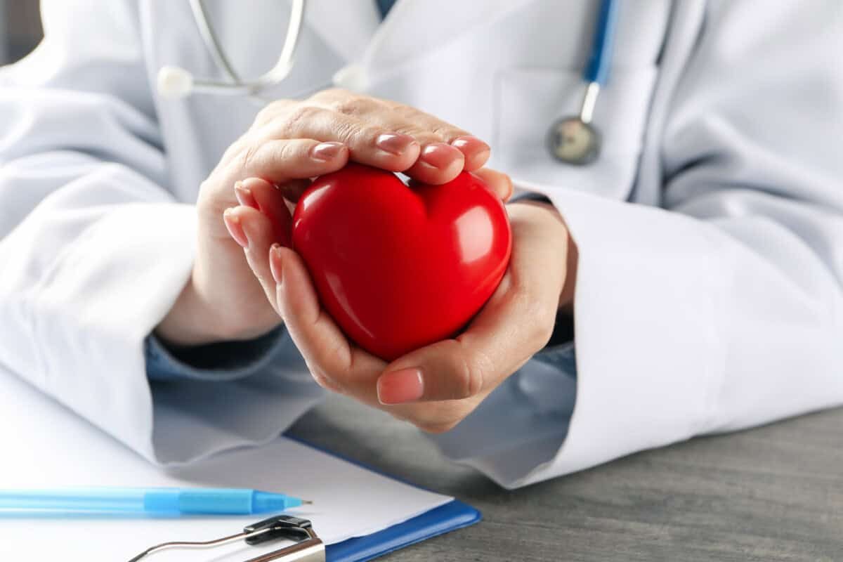 Female doctor with stethoscope holding red heart